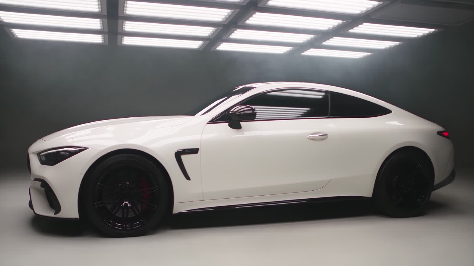The same white coupe after repair: straight panels, matched paint, the door and fender flush again